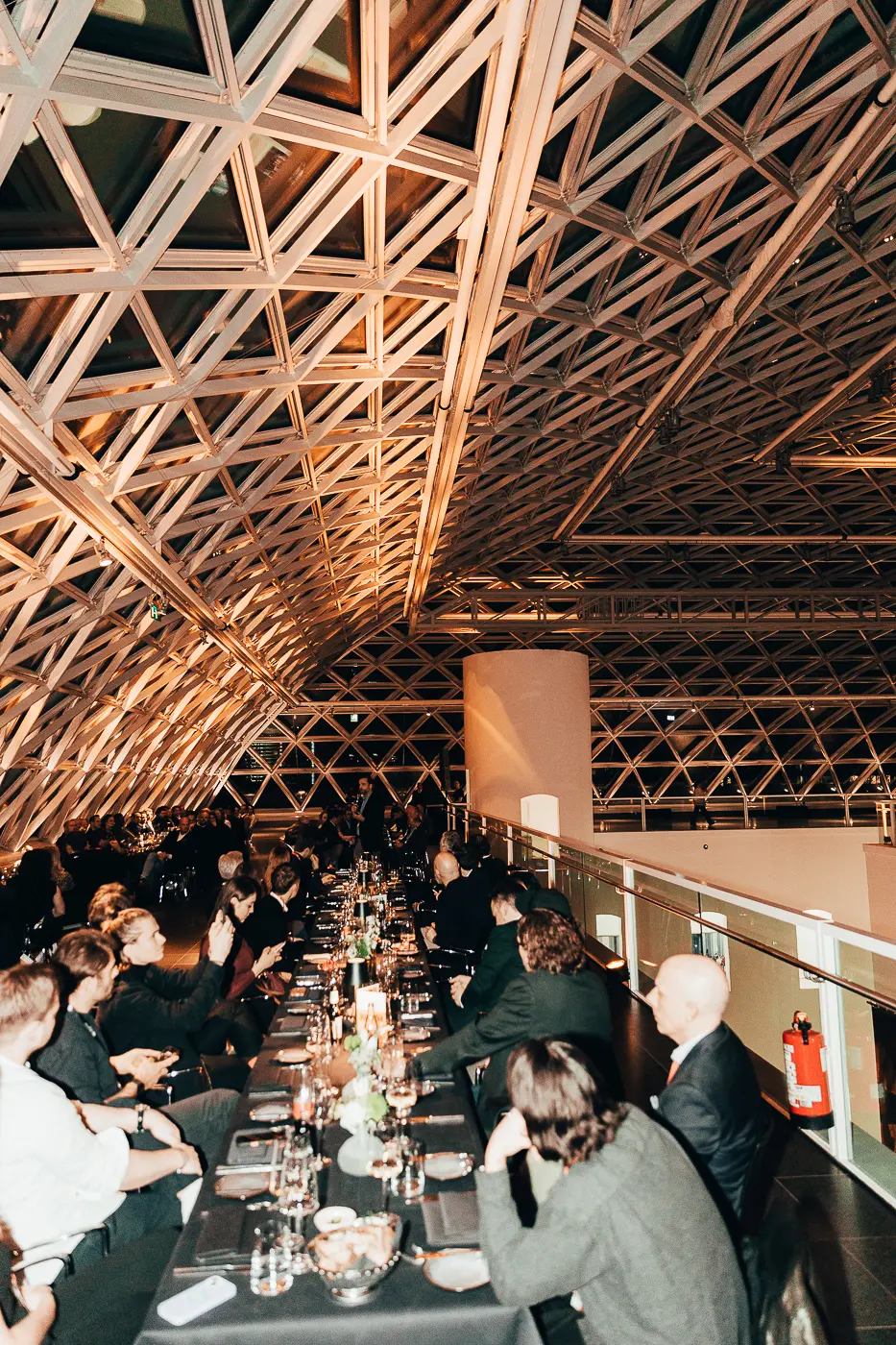Lang gedeckte Dinner-Tafel unter der markanten Glasdachkonstruktion